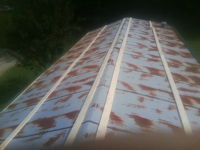 Rusted metal roof panels with new wood purlins before replacement — Storm Damage Roof Repair in Meldrim by Roofing Brothers