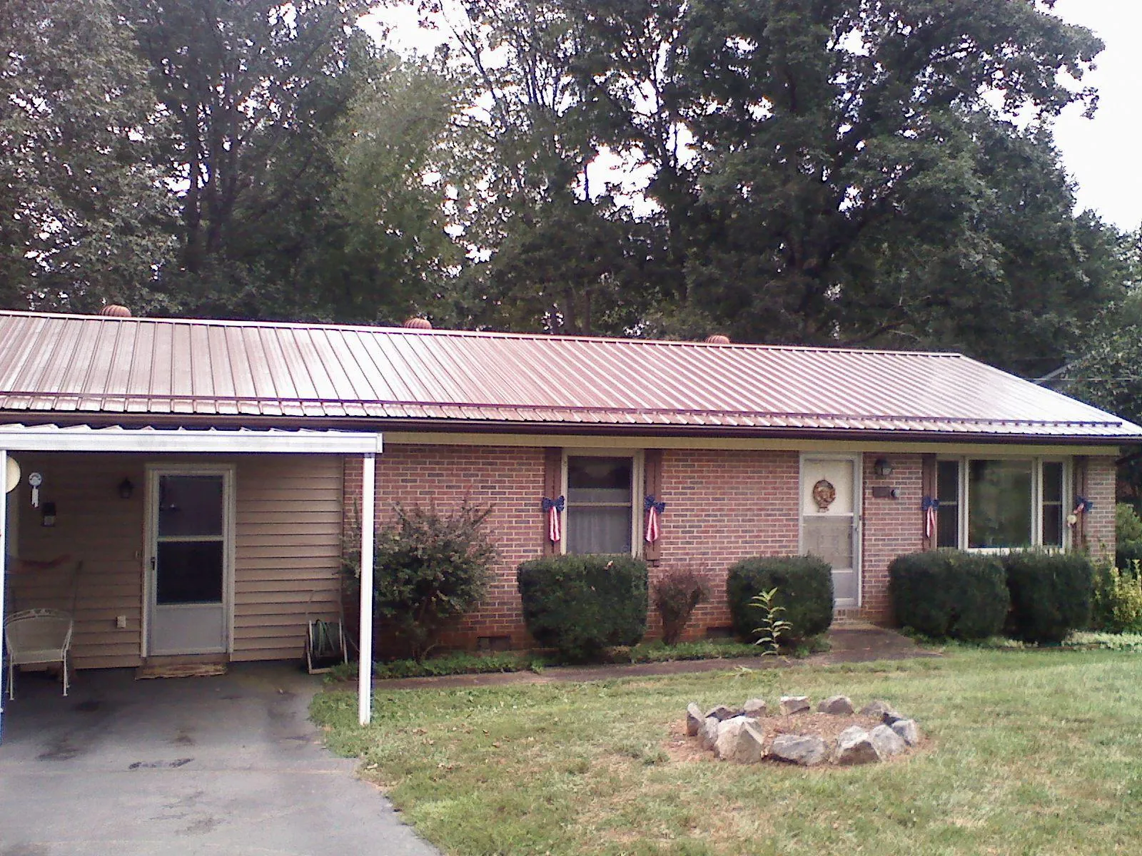 Bronze metal roof and carport on a brick ranch home — Roof Repair work by our crew in Meldrim