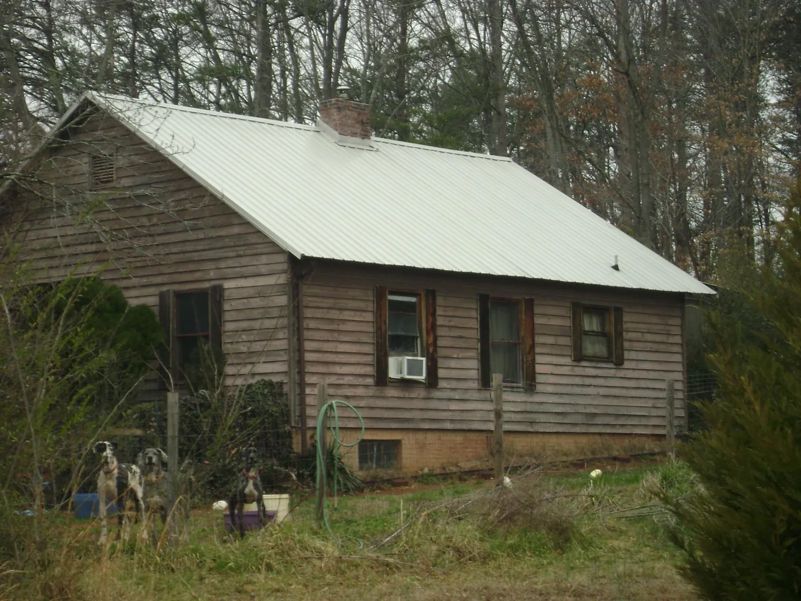 White metal roof on an old wood sided farmhouse, from a Metal Roof Installation job in Meldrim